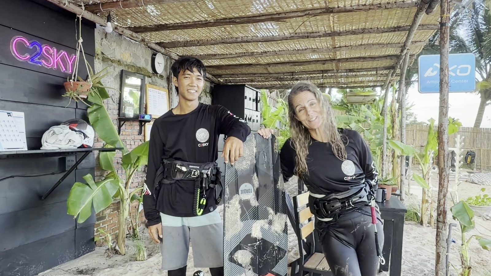 The new C2SKY Kite Center at Sea Lion: the counter under the thatch roof, Liz and an instructor smiling
