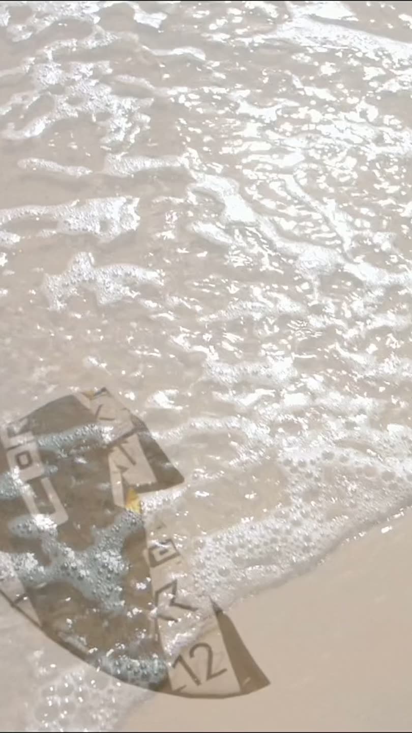 ジャンプの頂点にいるカイトサーファー。霞んだ空の下、水面のはるか上。