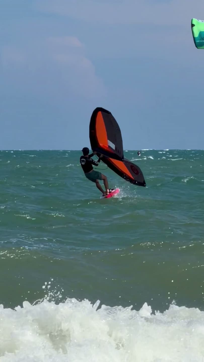水面から浮き上がるウイングフォイラー。ボードとフォイルが水を離れ、頭上にウイングを掲げています。ムイネー沖にて。