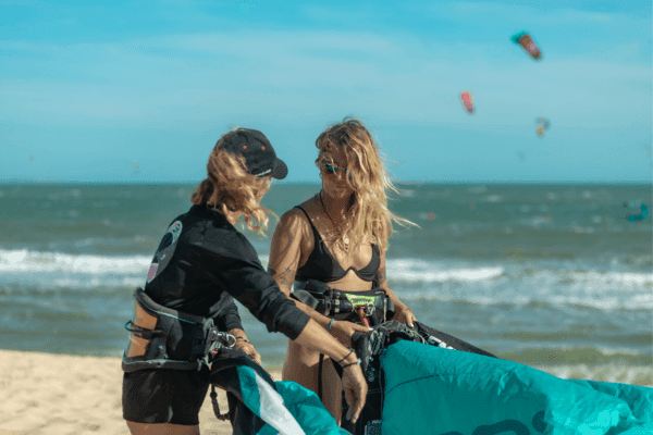 Liz, founder and IKO Level 2 instructor at C2SKY, demonstrating how to pump up a kite on the beach in Mui Ne, Vietnam, on a sunny, windy day.